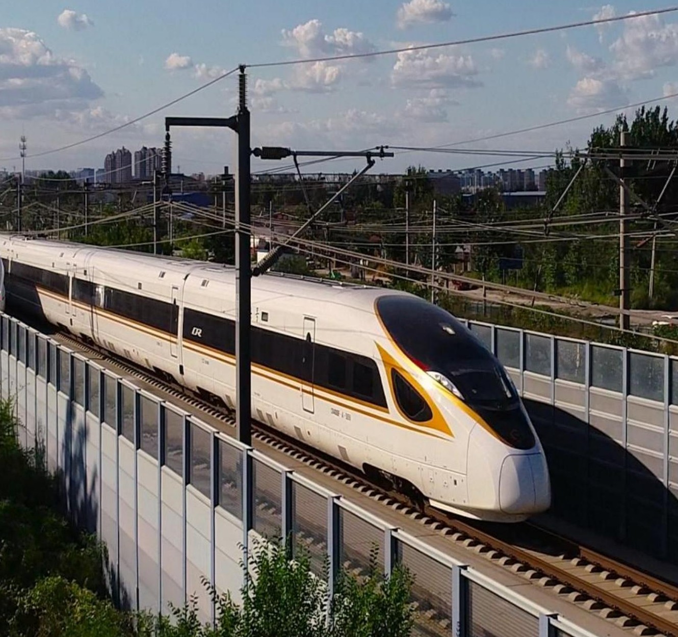 High-speed train running beside a trackside noise barrier in China